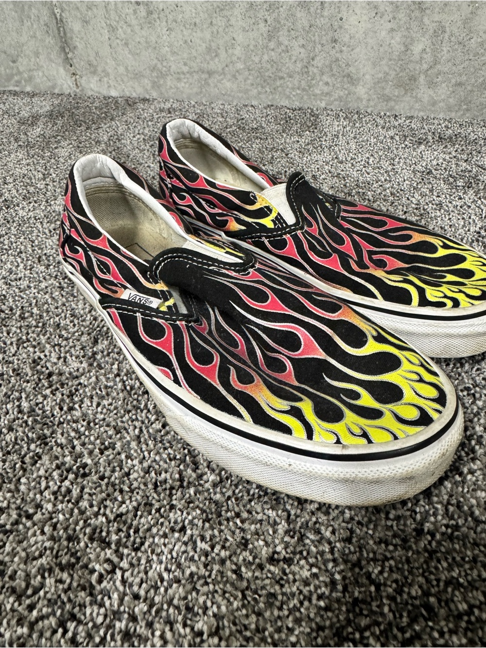 Vans Black Slip-On Sneakers with Red and Yellow Flame Print